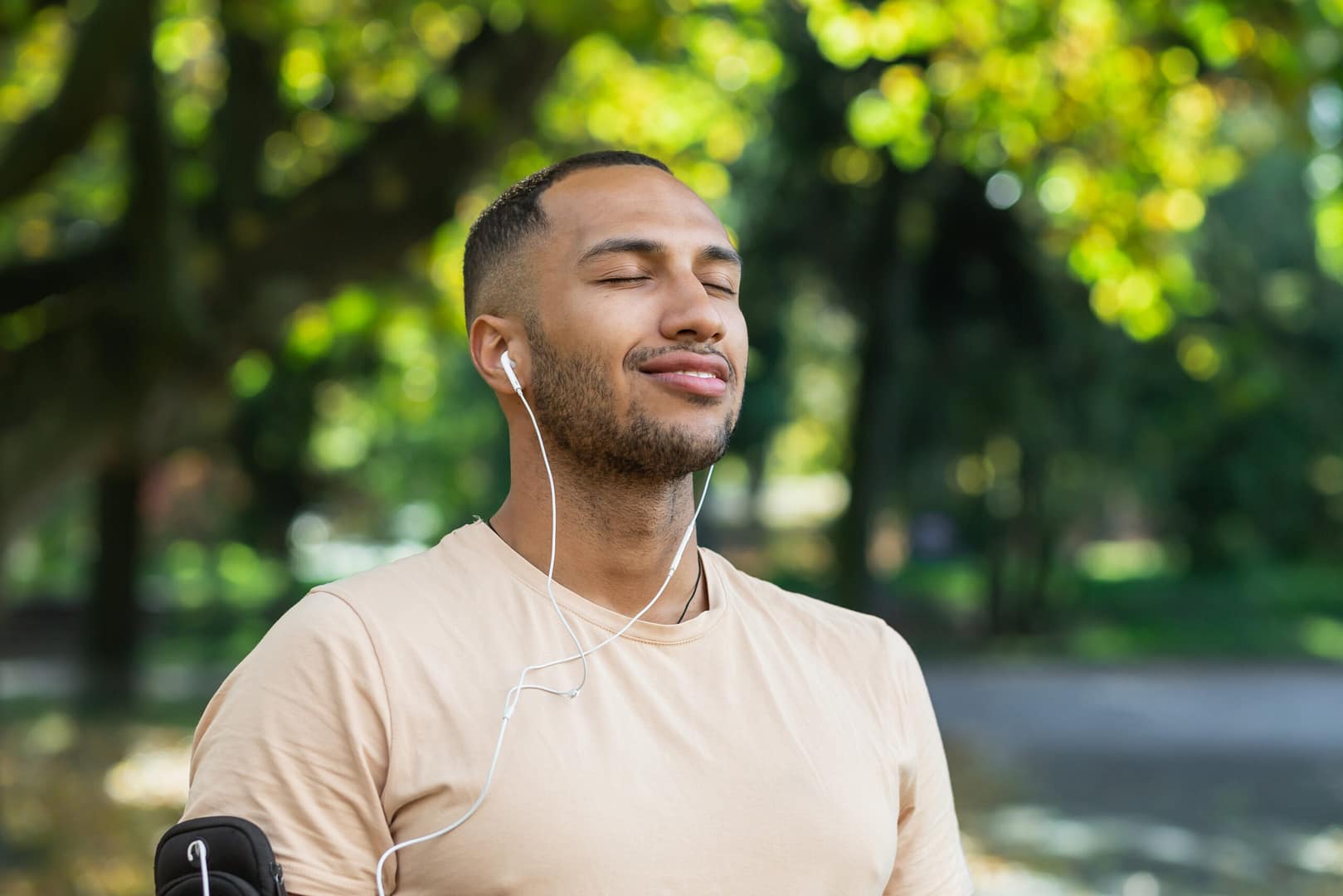 Man outdoors with eyes closed and earbuds representing peace and mental clarity through IV ketamine therapy at Better Health Whole Wellness Center Philadelphia